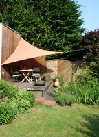 Schattenplatz auf der Gartenterrasse mit Dreiecksegel terracotta